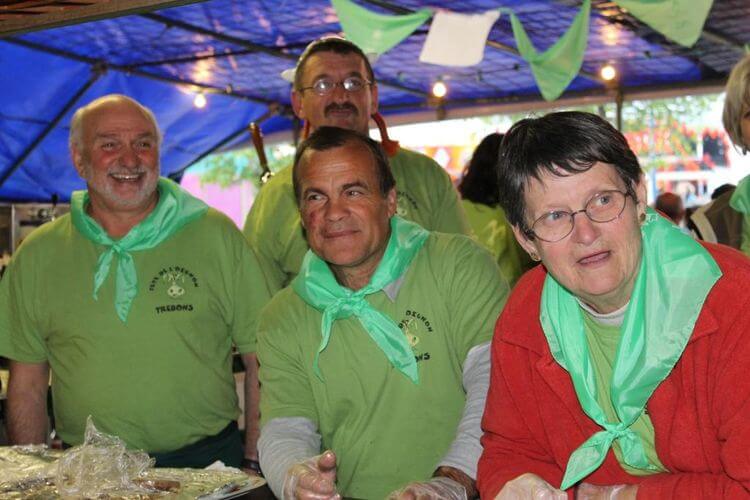 Un petit groupe de personne à la fête de l'oignon de trébons avec un foulard vert autour du coup